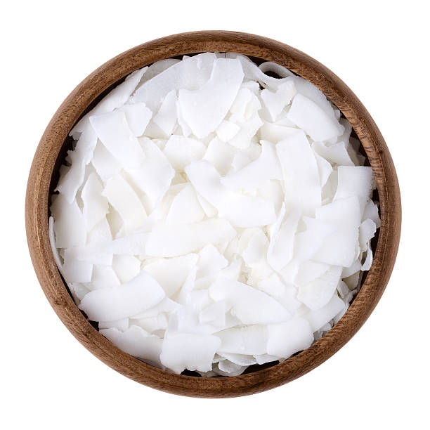 Coconut flakes in a bowl on white background