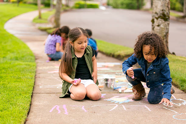 istock Young girls talking and drawing with chalk 588372186