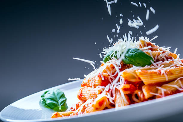pasta penne mit tomaten-bolognese-sauce, parmesan-käse und basilikum. - pasta stock-fotos und bilder