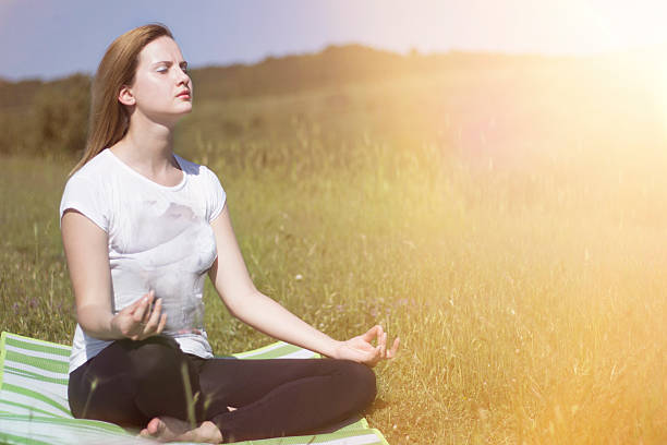 istock woman meditating in on the hill at the sunlight 588373386