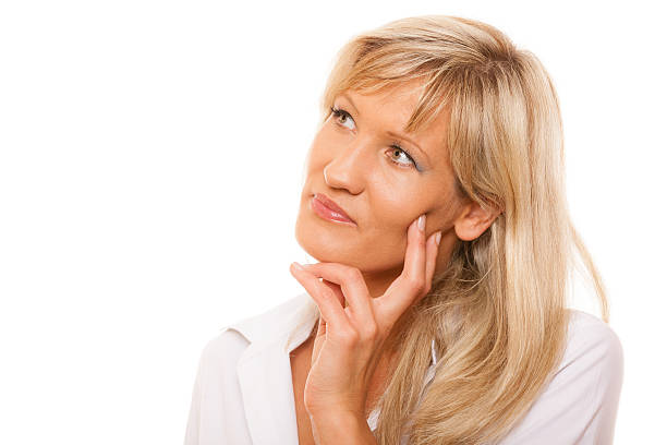 istock Thinking mature woman looking up isolated 588373590