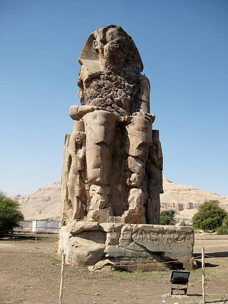 One of the Colossi of Memnon in Luxor, Egypt Luxor, Egypt - November 03, 2008: View of one of the Colossi of Memnon partially damaged. oracular stock pictures, royalty-free photos & images