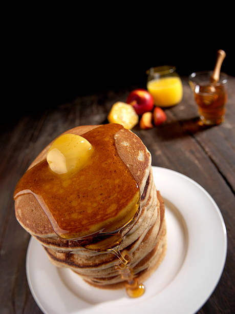 istock PANCAKES TOWER, HONEY AND BUTTER, BROWN TABLE WITH WHITE PLATE 588378332