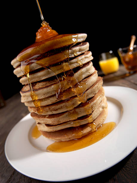 istock PANCAKES TOWER, HONEY AND BUTTER, BROWN TABLE WITH WHITE PLATE 588378400