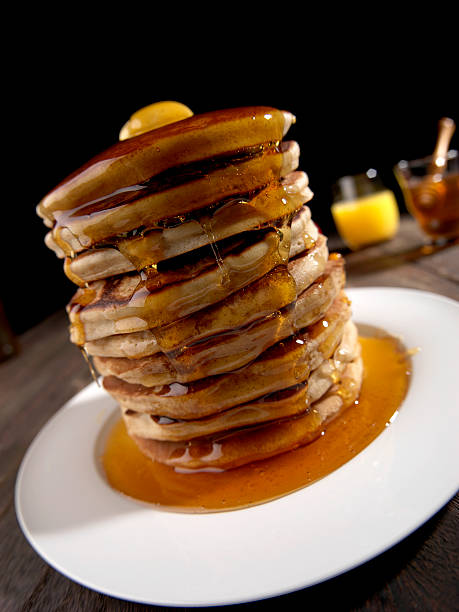 istock PANCAKES TOWER, HONEY AND BUTTER, BROWN TABLE WITH WHITE PLATE 588378464