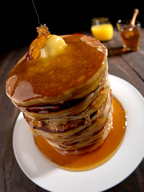 istock PANCAKES TOWER, HONEY AND BUTTER, BROWN TABLE WITH WHITE PLATE 588378496