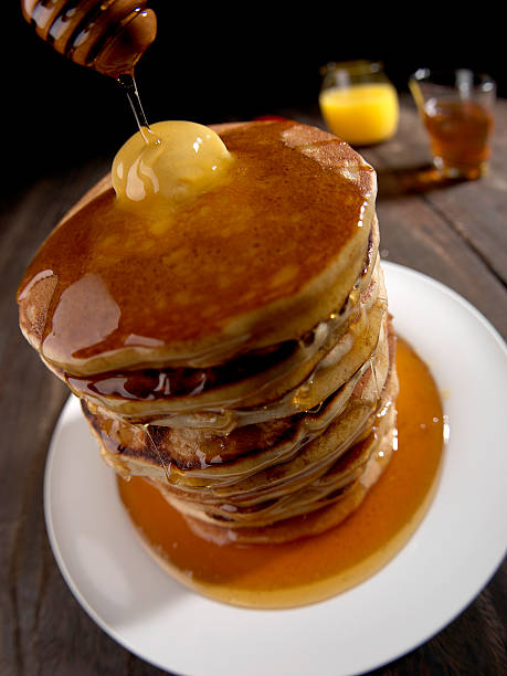 istock PANCAKES TOWER, HONEY AND BUTTER, BROWN TABLE WITH WHITE PLATE 588378528