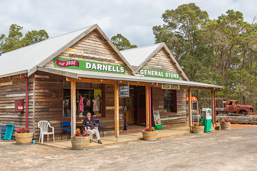 Rosa Brook, Australia - April 5, 2016: An unidentified man sits outside a general store in Rosa Brook, in the Margaret River area of Western Australia. The store is a reminder of the past.