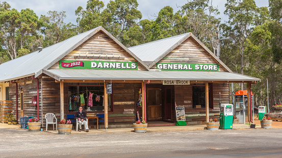 Rosa Brook, Australia - April 5, 2016: An unidentified man sits in front of a general store in Rosa Brook, in the Margaret River area of Western Australia. The store is a quaint reminder of the past.