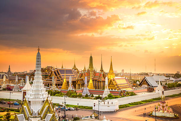 The beauty of the Emerald Buddha Temple at twilight. The beauty of the Emerald Buddha Temple at twilight. And while the gold of the temple catching the light. This is an important buddhist temple of thailand and a famous tourist destination. theravada photos stock pictures, royalty-free photos & images