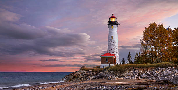 Sunset at the Crisp Point Lighthouse As daylight begins yielding to twilight, The Crisp Point Lighthouse at sunset on Lake Superior, Upper Peninsula, Michigan, USA - A one hour drive from Tahquamenon Falls, mostly dirt roads lighthouse stock pictures, royalty-free photos & images