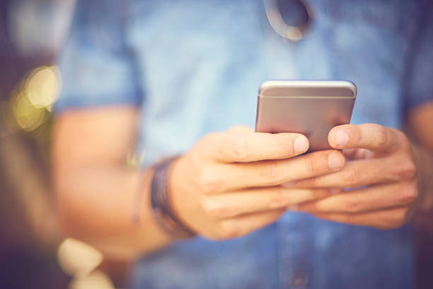 istock Midsection of man texting through smart phone 588384936