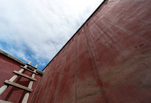 wooden ladder beside red wall