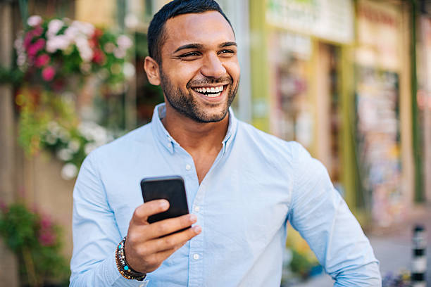 istock Cheerful young man with smart phone outdoors 588389590