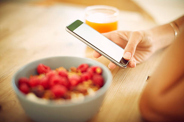 istock Woman with smart phone and breakfast at table 588390862