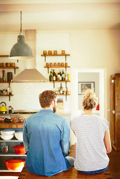 istock Rear view of couple sitting on trunk in kitchen 588392040