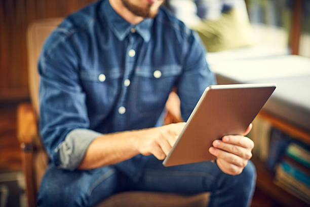 istock Midsection of male blogger using digital tablet at home 588392414