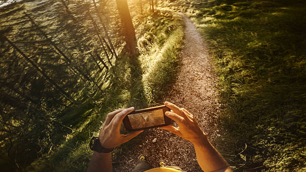 pov trail работает в лесу: проверка карты на мобильном телефоне - jogging cross country running hiking outdoors стоковые фото и изображения