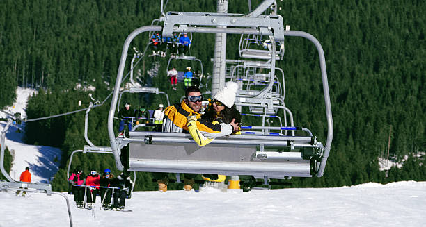 istock Cheerful young couple moving down with ski lift 588393156