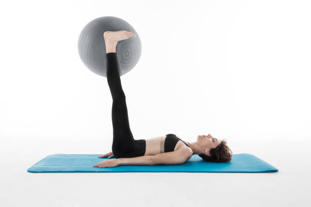 istock young woman doing exercising with pilates ball 588393678
