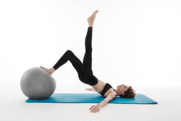 istock young woman doing exercising with pilates ball 588394294