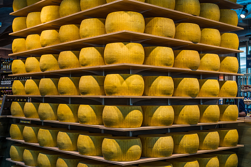 Parma, Italy - July 23, 2016. Wheels of Parmigiano-Reggiano or Parmesan cheese on the shelves of Ghiaia market in Parma. Emilia-Romagna.