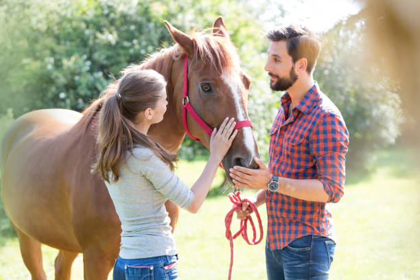 istock Couple petting horse 588482639
