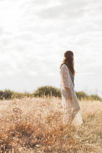 istock Serene boho woman standing in rural field 588482703