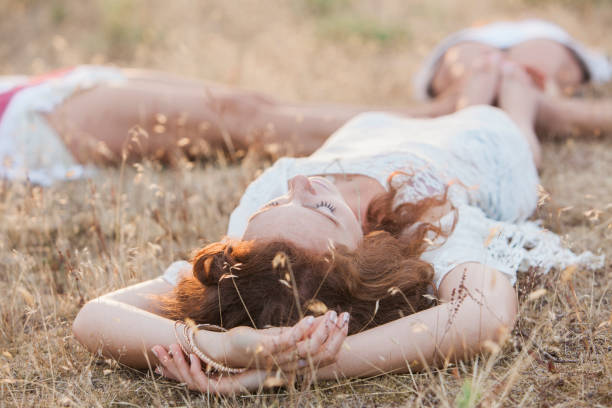 Boho women laying in circle with feet touching in rural field  hippie photos stock pictures, royalty-free photos & images
