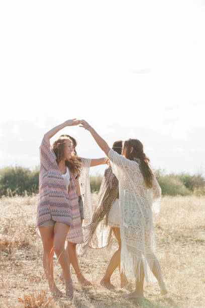 istock Boho women dancing in circle in sunny rural field 588482723
