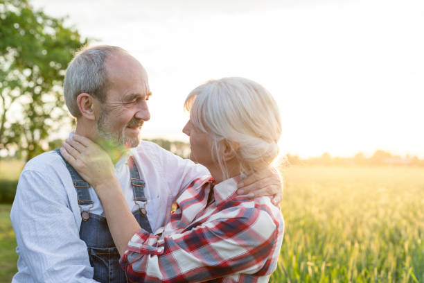 istock Affectionate senior couple hugging in sunny rural wheat field 588482813