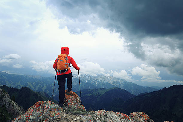 istock successful woman hiker enjoy the view on mountain top cliff 588575180