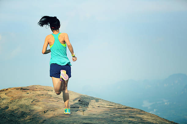 istock young asian woman runner running on mountain peak 588578804