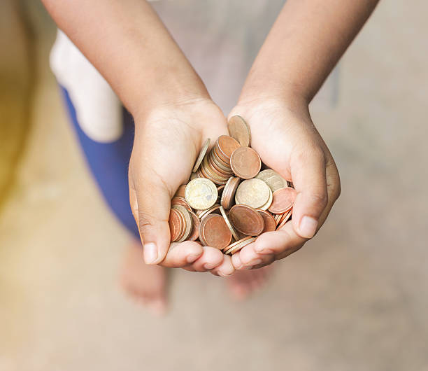 istock Hand of child with coins 588588368