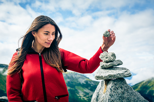 Young Woman at the Top of the Mountain. Shot taken in Swiss Alps, near Rhone Glacier and Furka Pass.
