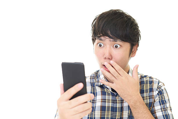 istock Surprised Asian man with a smart phone 588588984