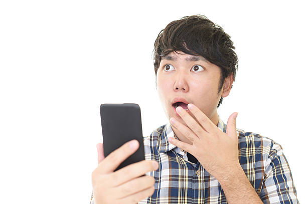 istock Surprised Asian man with a smart phone 588589076