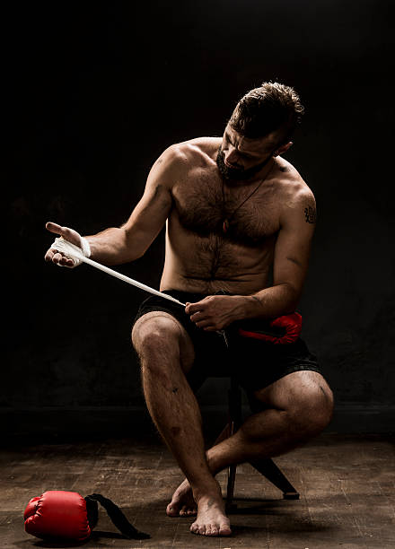 istock Boxer tying tape around his hand preparing to fight 588589292