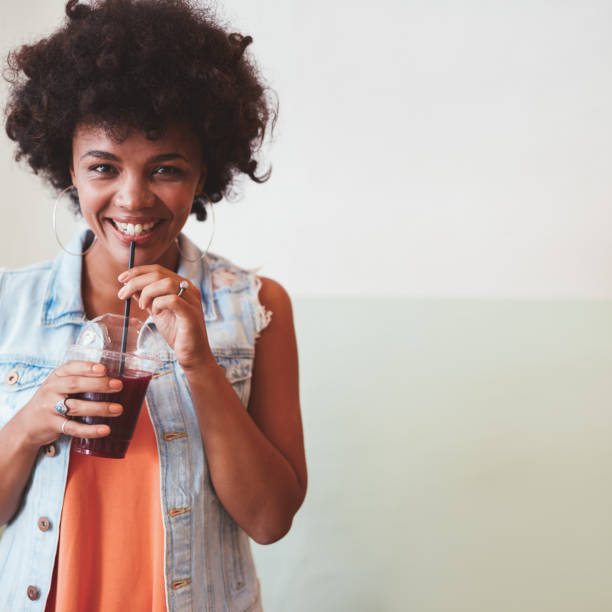istock Happy young woman having a fresh fruit juice 588590420