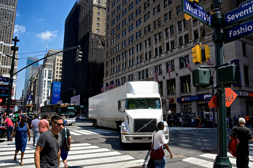 New York City, USA - August 05, 2016: A Tractor-Trailer stops to allow pedestrians cross W.31st Street at Seventh Avenue in busy Lower Midtown Manhattan.