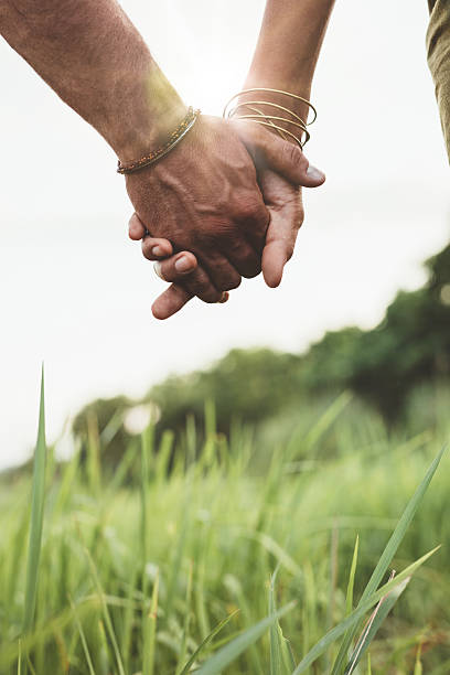 istock Beautiful couple holding hands on the field 588591940