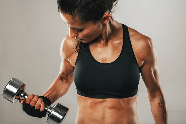 istock Strong healthy young women lifting weights 588592764
