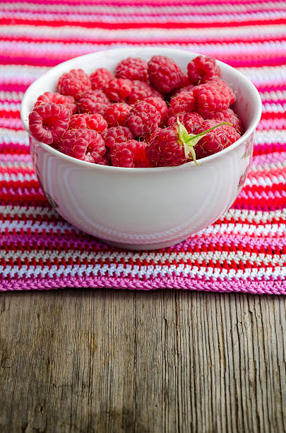 istock plate with raspberries stands on crocheted striped doily 588593712