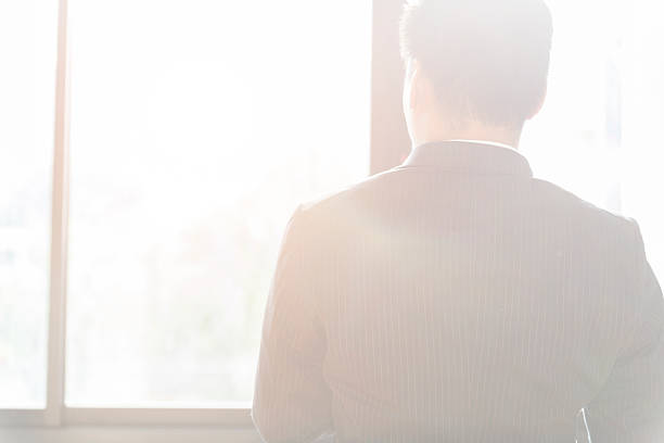 istock back of businessman in suit looking through office 588593968