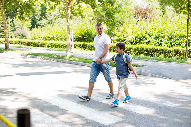 niño cruzando la calle con su padre - familia de cruzar la calle fotografías e imágenes de stock