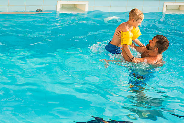 istock Father and son swimming together 588594960