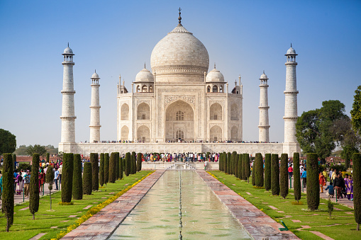 The magnificent Taj Mahal, situated in the city of Agra, and its flow of tourists on a sunny Spring day.