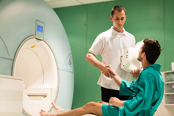 Radiologist helping patient with MRI scanning machine Radiologist helping patient with MRI scanning machine. male nurse male healthcare and medicine technician stock pictures, royalty-free photos & images