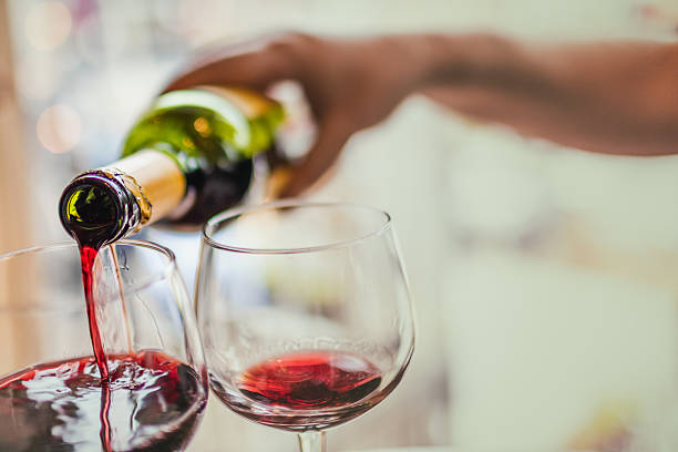 istock Pouring red wine in glasses 588596902