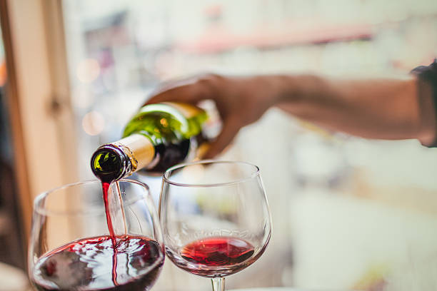 istock Pouring red wine in glasses 588596930